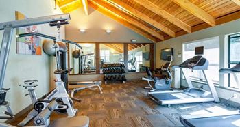 a room filled with lots of different types of exercise equipment at The Lakes Apartments, Washington, 98007